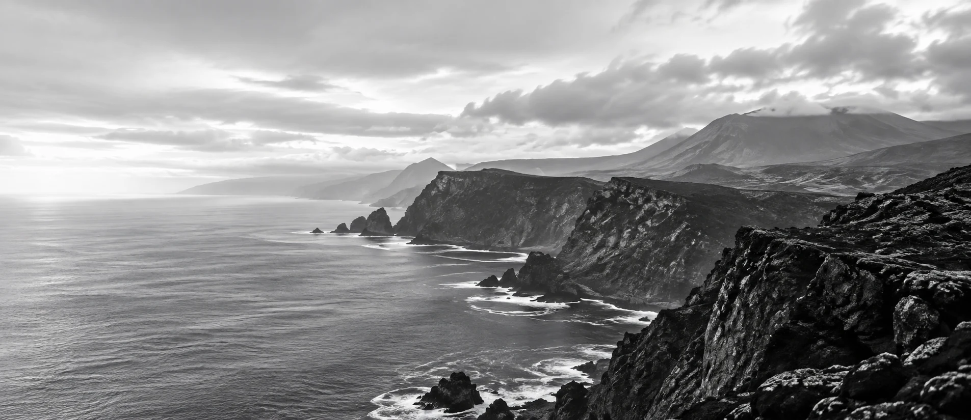 Falésias marítimas dos Açores sob um céu claro e nublado